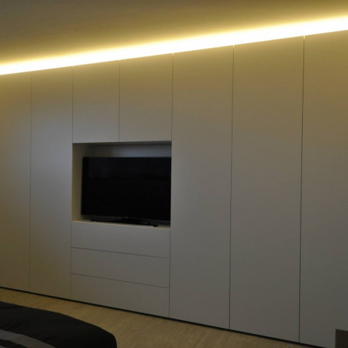 De bewoners wouden in hun slaapkamer een wandkast waarbij de TV werd ingewerkt. Wij zorgden voor extra sfeer door boven de kast dimbare led-verlichting te voorzien. Kast-ID Asse